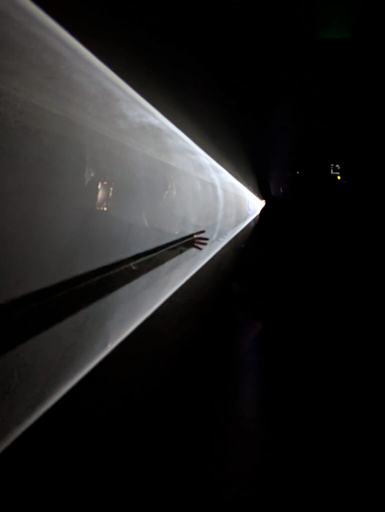 fingers reach through the cone of light