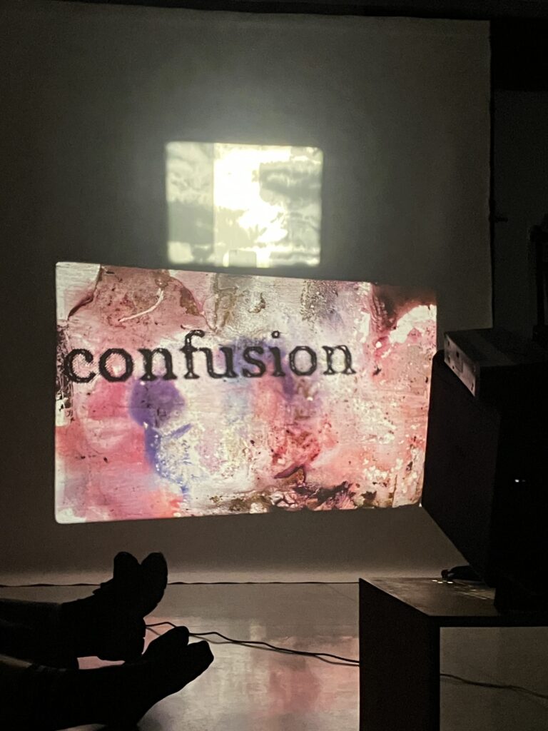 Image of performance by Adit including 16mm and slide projector and live music